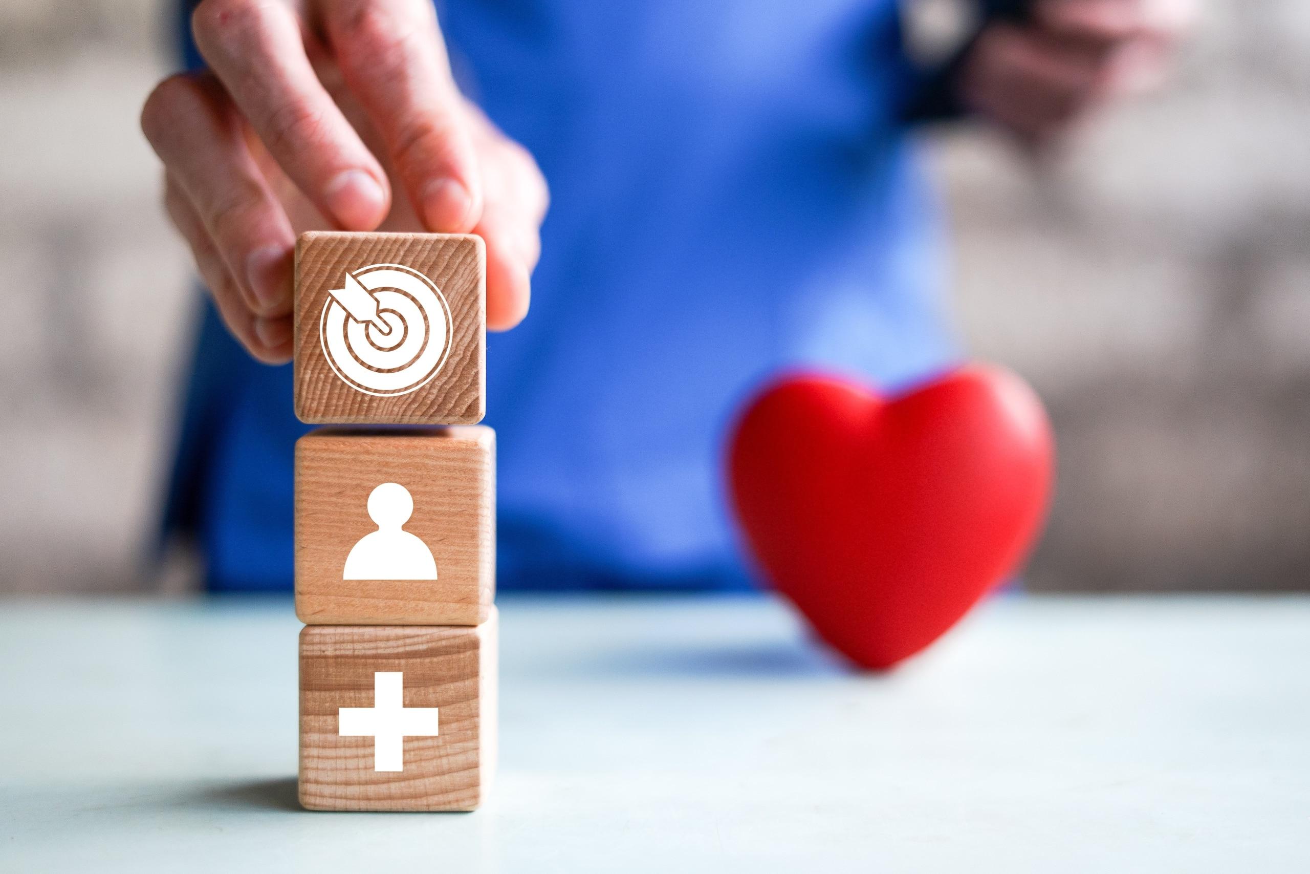 Close up of a nurse stacking blocks with healthcare symbols